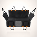 RoadTuck SeatSpan dog backseat extender in black with orange trim, hard bottom platform extended across the rear footwell